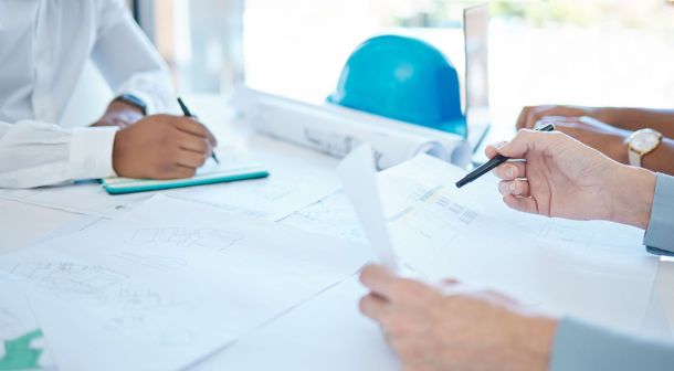 hands of planning colleagues looking at plans at desk