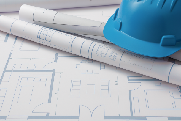 Housing plans with hard hat for planning permission