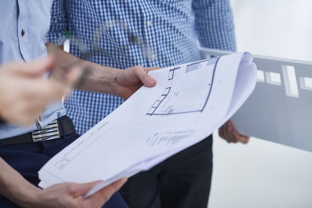 planning colleagues in office looking at blueprints